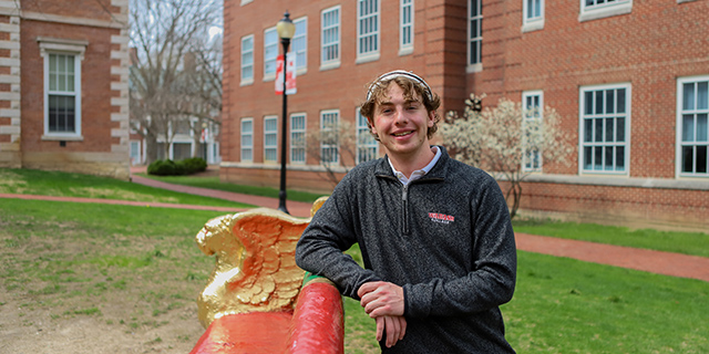 Austin Pickett smiles towards the camera seated on the senior bench.